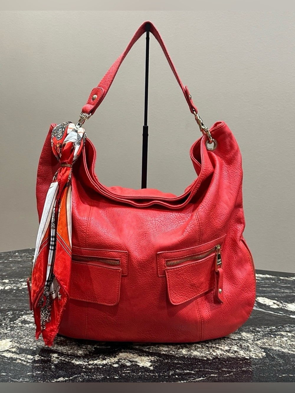 Steve Madden red hobo bag features a shoulder strap and two front zipper pockets
